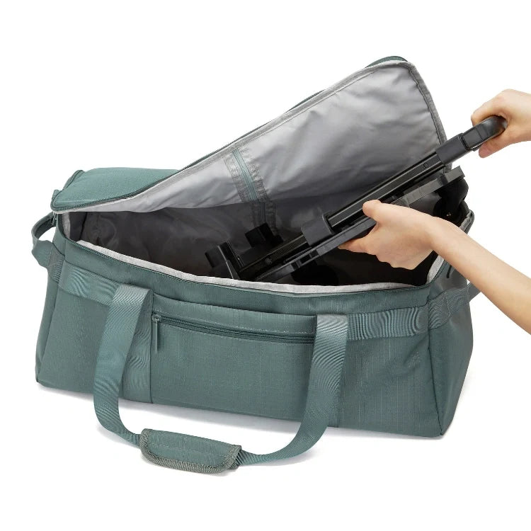 Green and gray duffel bag with handle being grabbed.